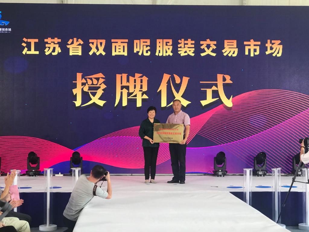 江苏省纺织协会为无锡东港双面呢服装市场总经理周裕翔授牌一一江苏省双面呢服装交易市场.jpg
